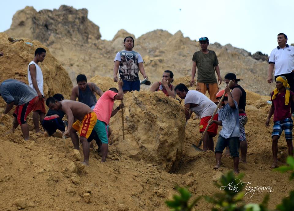 A group of people digging for possible landslide survivor